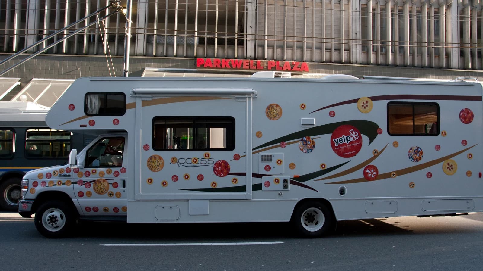 Автодом с фирменной символикой Yelp стоит на городской улице.
