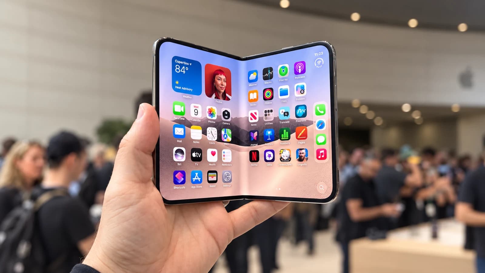 ИИ-иллюстрация: Раскрытый iPhone Duo в руке на демонстрационной площадке