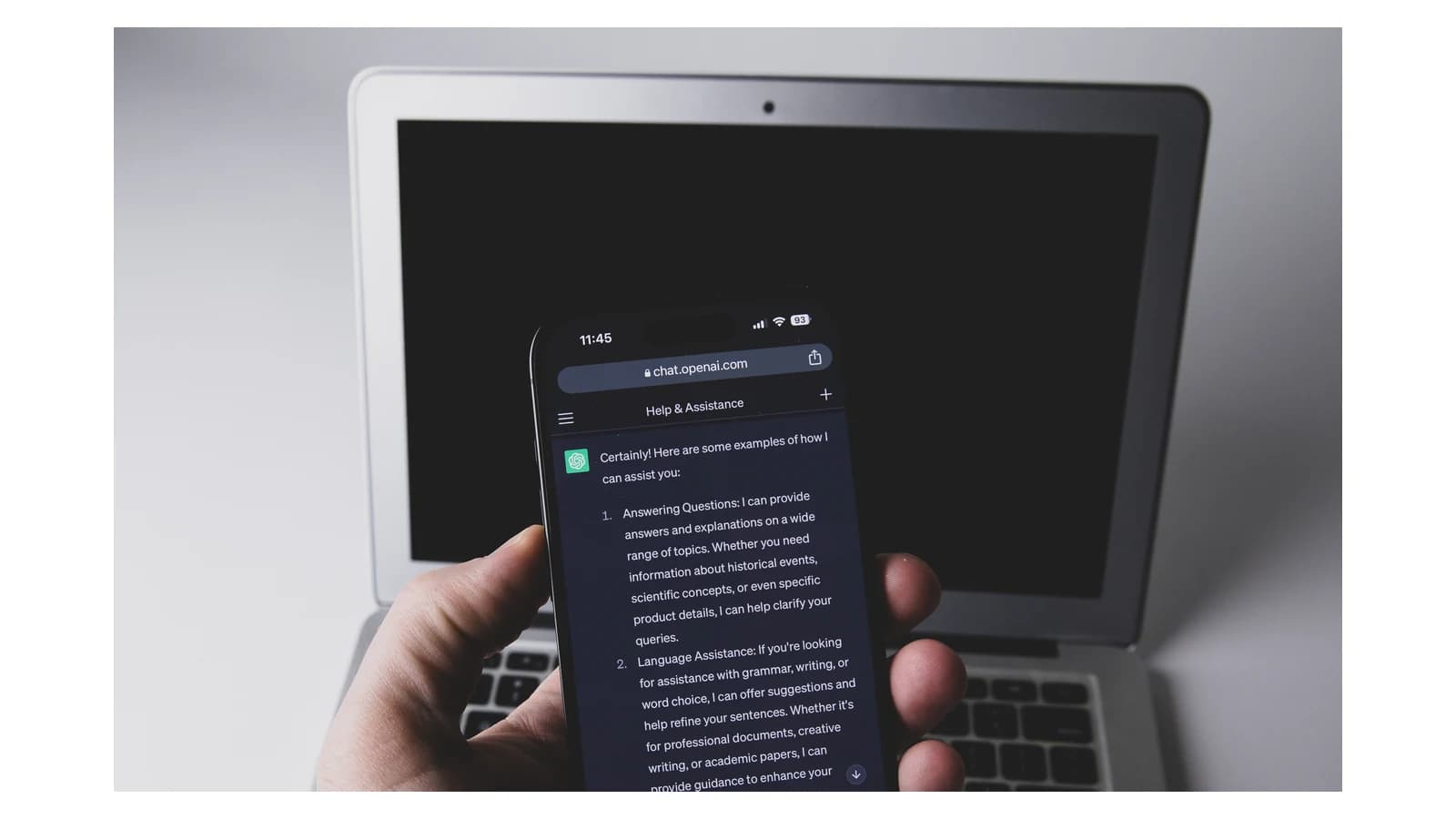 ChatGPT открыт на смартфоне перед ноутбуком